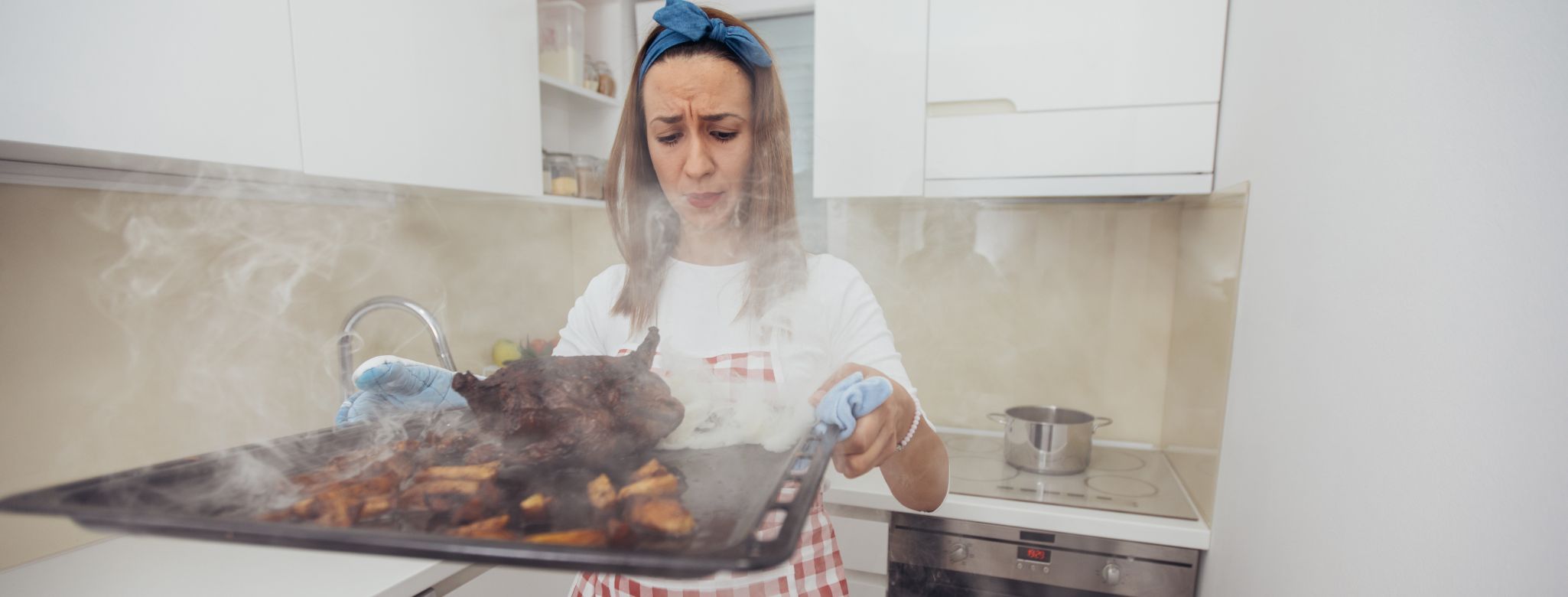 Žena v kuchyni s rozpáleným pekáčem - pozor na popáleniny